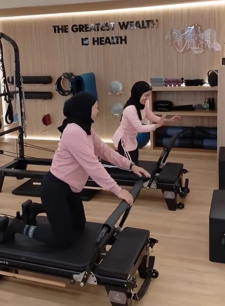 Two women training side by side on reformers