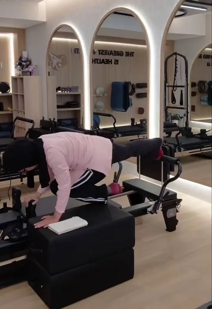A client working on the box on the reformer, arched mirrors behind